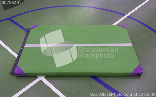 Image of Very old green mat on a blue court