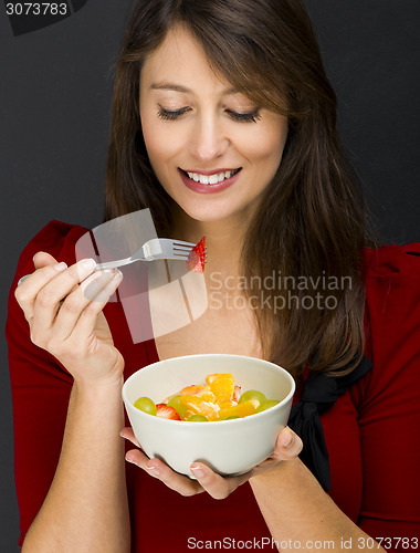 Image of Woman eating a fruit salad