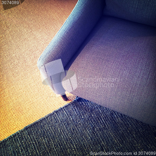 Image of Blue textile armchair and knitted carpet