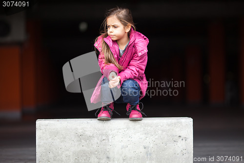 Image of A sad little girl crouching down