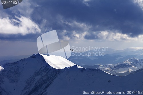 Image of Off-piste slope for heliskiing and helicopter in evening