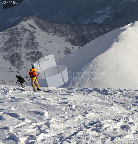 Image of Freeriders on off-piste slope in sun nice evening