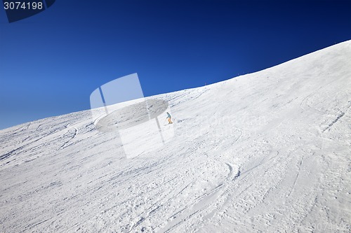 Image of Skier on slope in sun day