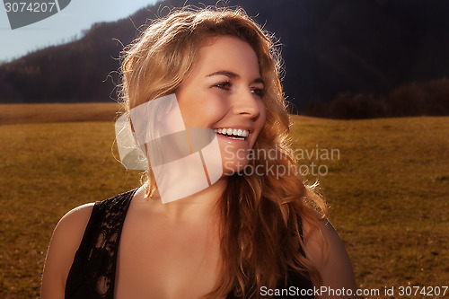 Image of Portrait of a laughing blond girl with golden hair.