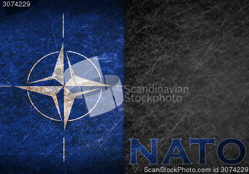 Image of Old rusty metal sign with a NATO flag