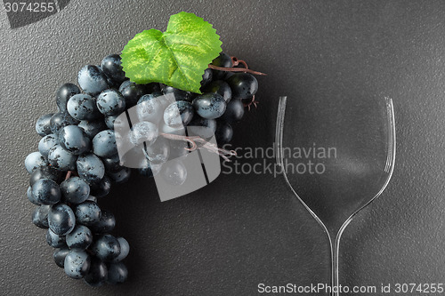 Image of Wine glass made of forks and grape on black