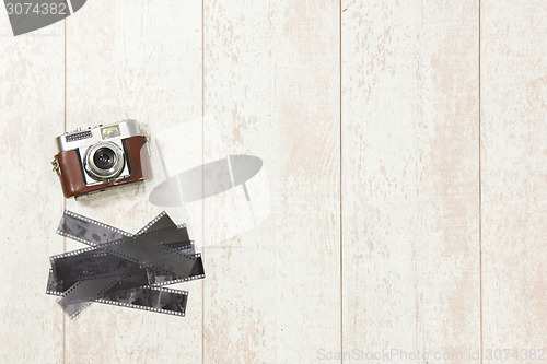 Image of Vintage Camera And Film Strips On Floorboard