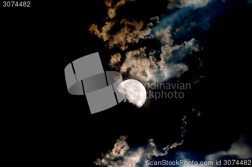 Image of Big Moon Over The Clouds In A Dark Night