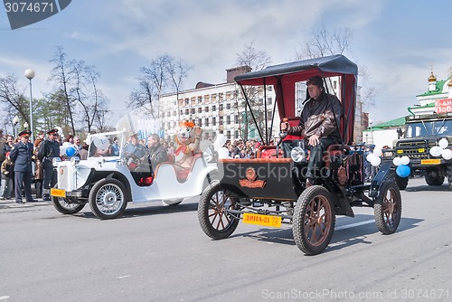 Image of Old-fashioned cars participate in parade