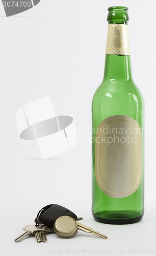 Image of empty beer bottle with car key and crown cork