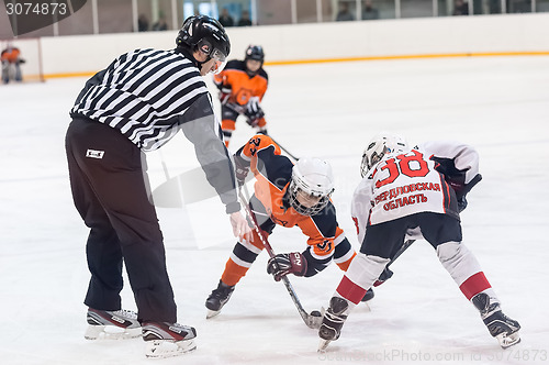 Image of Puck playing between players of ice-hockey teams