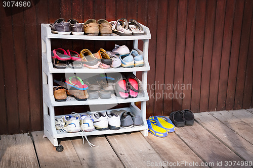 Image of Colorful Shoes on a Plastic Shoe Rack, Outside a House