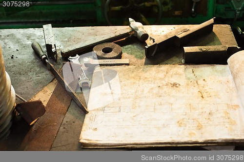 Image of Old tools on workplace of turner with chart