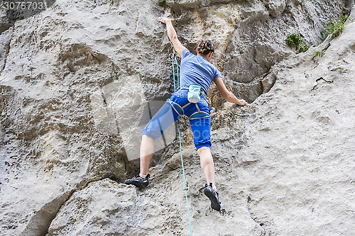 Image of Woman free climbing