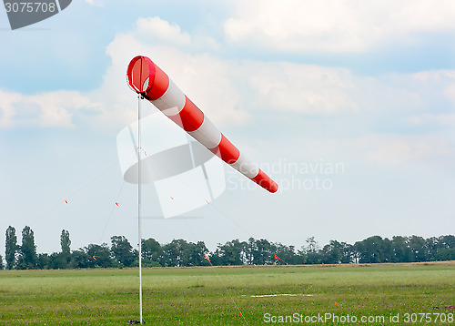 Image of Windsock against cloudy sky.