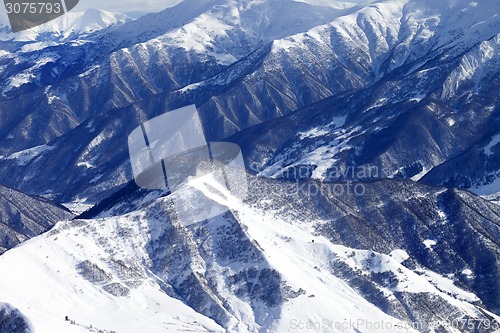 Image of Top view on snowy mountains with forest