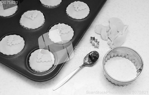 Image of Uncooked mince pies in a bun tin