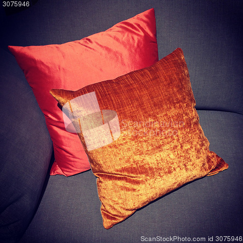 Image of Shiny red and orange cushions decorating a sofa