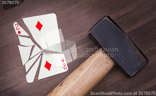 Image of Hammer with a broken card, two of diamonds