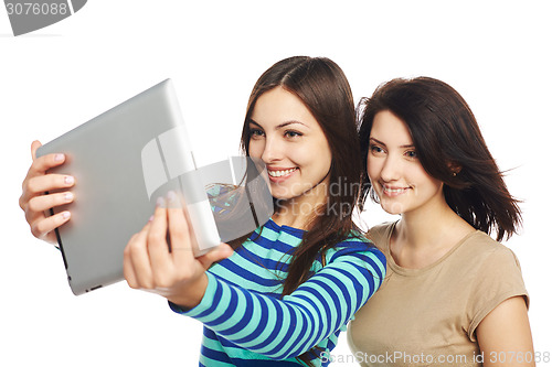 Image of Two girls friends taking selfie with digital tablet