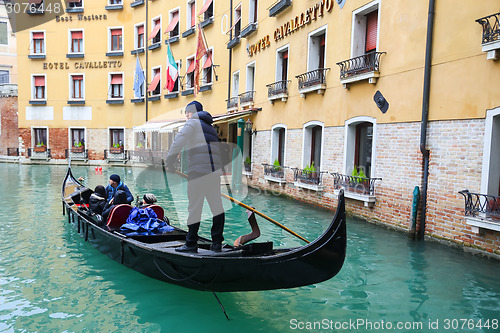 Image of Gondola with tourists sailing in Venice