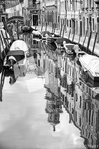 Image of Empty gondolas moored in water canal bw