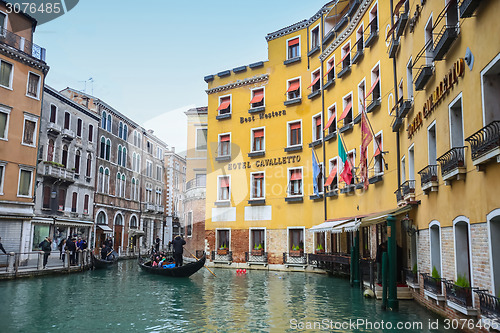 Image of Gondola with tourists sailing in water canal