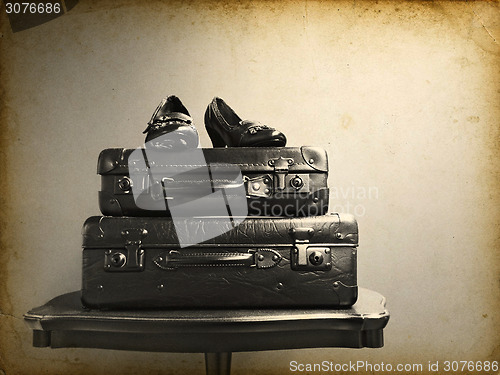 Image of Vintage suitcases and shoes on a table