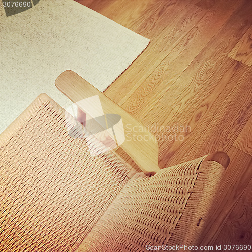 Image of Classic rattan chair on wooden floor