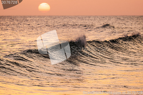 Image of Breaking wave at sunset