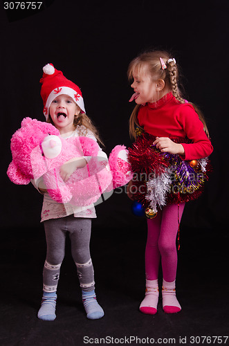 Image of Two girls in Christmas clothes grimace