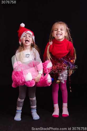 Image of Two girls grimace and show language in Christmas clothes