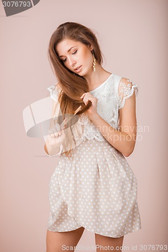 Image of Smiling Girl combs her hair