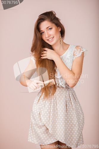 Image of Smiling Girl combs her hair