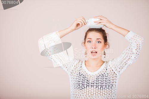 Image of Suprised Woman with cup and saucer