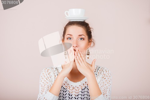 Image of Suprised Woman with cup and saucer