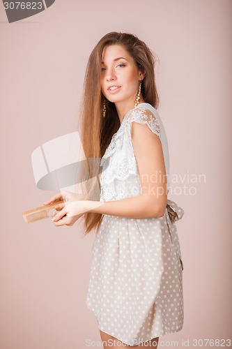 Image of Smiling Girl combs her hair