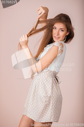 Image of Smiling Girl combs her hair