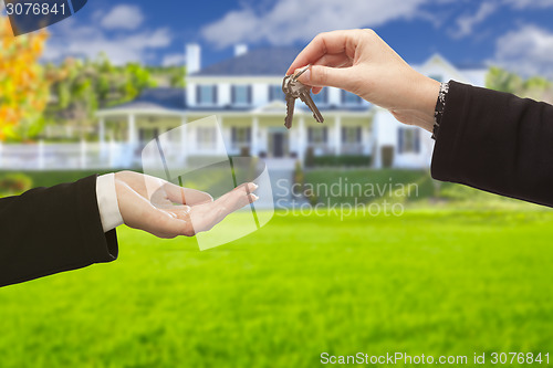 Image of Agent Handing Over House Keys in Front of New Home