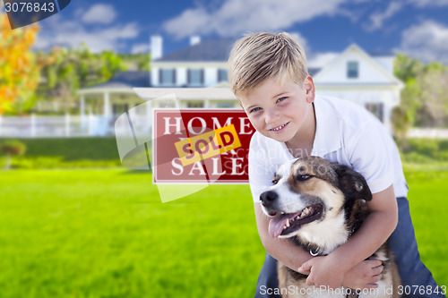 Image of Boy and His Dog in Front of Sold Sign, House