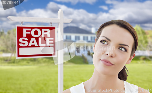 Image of Thinking Woman In Front of House and For Sale Sign