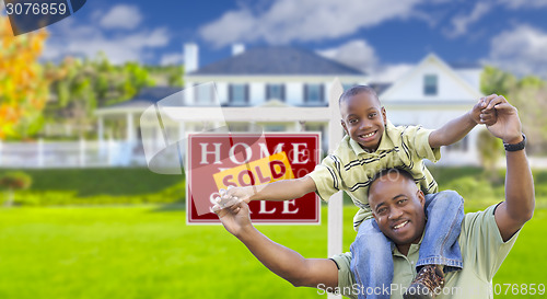 Image of Father and Son In Front of Real Estate Sign and Home