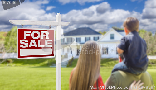 Image of Family Facing For Sale Real Estate Sign and House