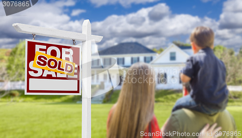 Image of Family Facing Sold For Sale Real Estate Sign and House