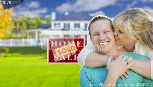 Image of Happy Couple In Front Sold Real Estate Sign and House