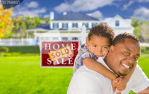 Image of Father and Son In Front of Sold Sign and House