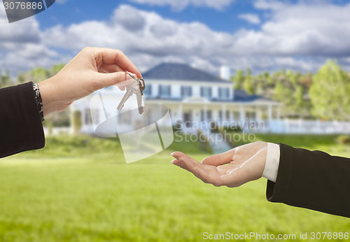 Image of Agent Handing Over House Keys in Front of New Home