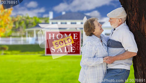 Image of Sold Real Estate Sign with Senior Couple in Front of House