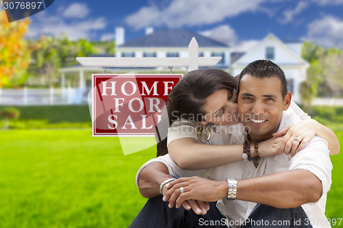 Image of Hispanic Couple, New Home and For Sale Real Estate Sign