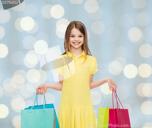 Image of smiling little girl in dress with shopping bags